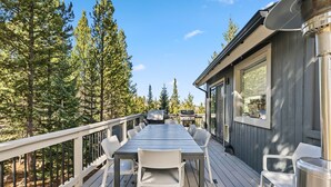 A deck with a table and chairs, surrounded by trees. - Breckenridge Mountain Retreat | Hot Tub & Views (Breckenridge)