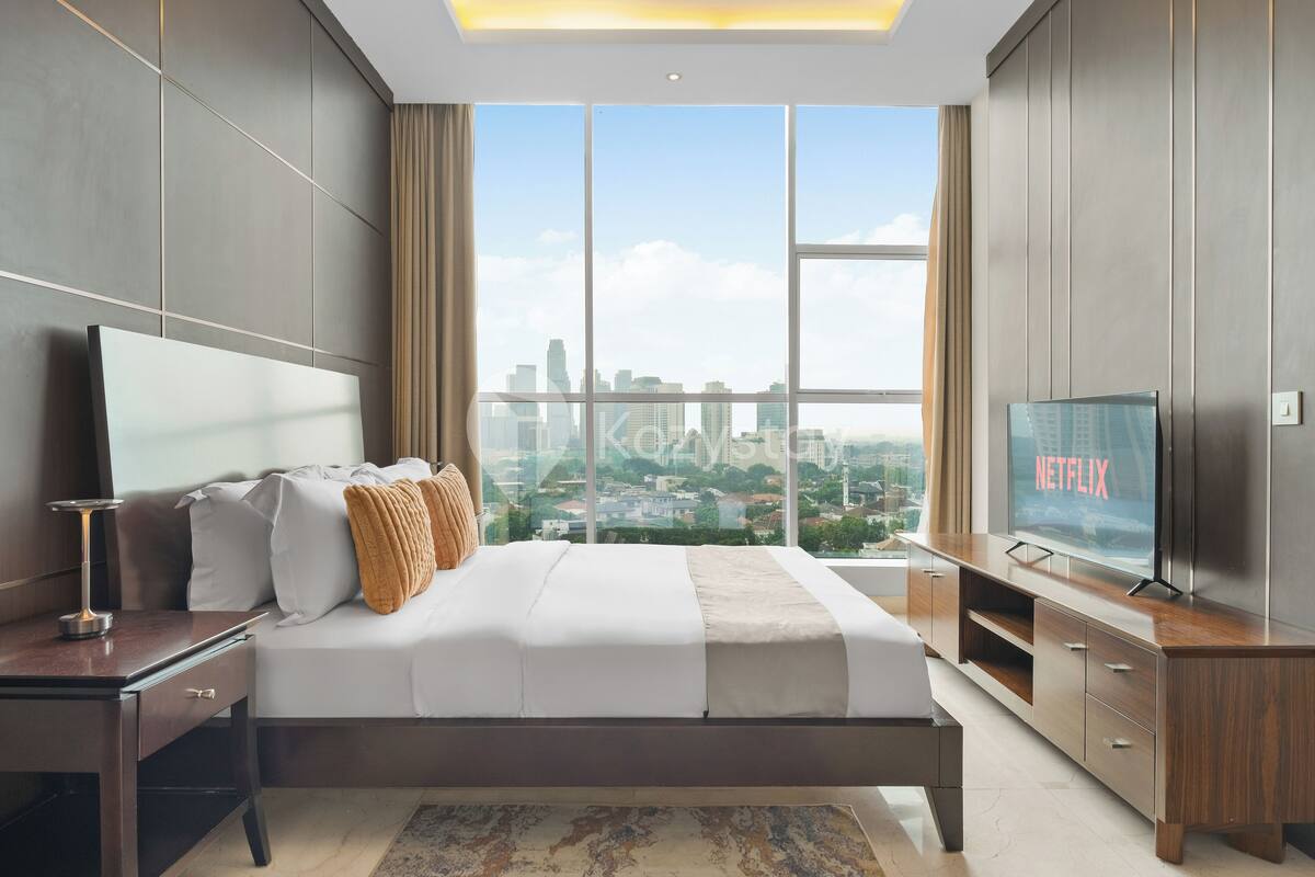 Habitación de hotel moderna con una cama grande, televisión y vista del horizonte de la ciudad.