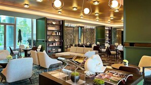 A modern lounge area with seating, bookshelves, and a coffee bar. - THE MORDIN HOTEL (Guangzhou)