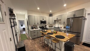 A modern kitchen with a central island, stainless steel appliances, and a clean, minimalist design.