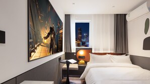 A hotel room with a bed, a desk, a chair, a nightstand, a window with a city view, and a painting on the wall. - Mcsrh Hotel-Chengdu Chunxilu (Chengdu)