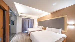 Une chambre d’hôtel avec deux lits, un grand miroir, un téléviseur à écran plat et un luminaire au plafond.