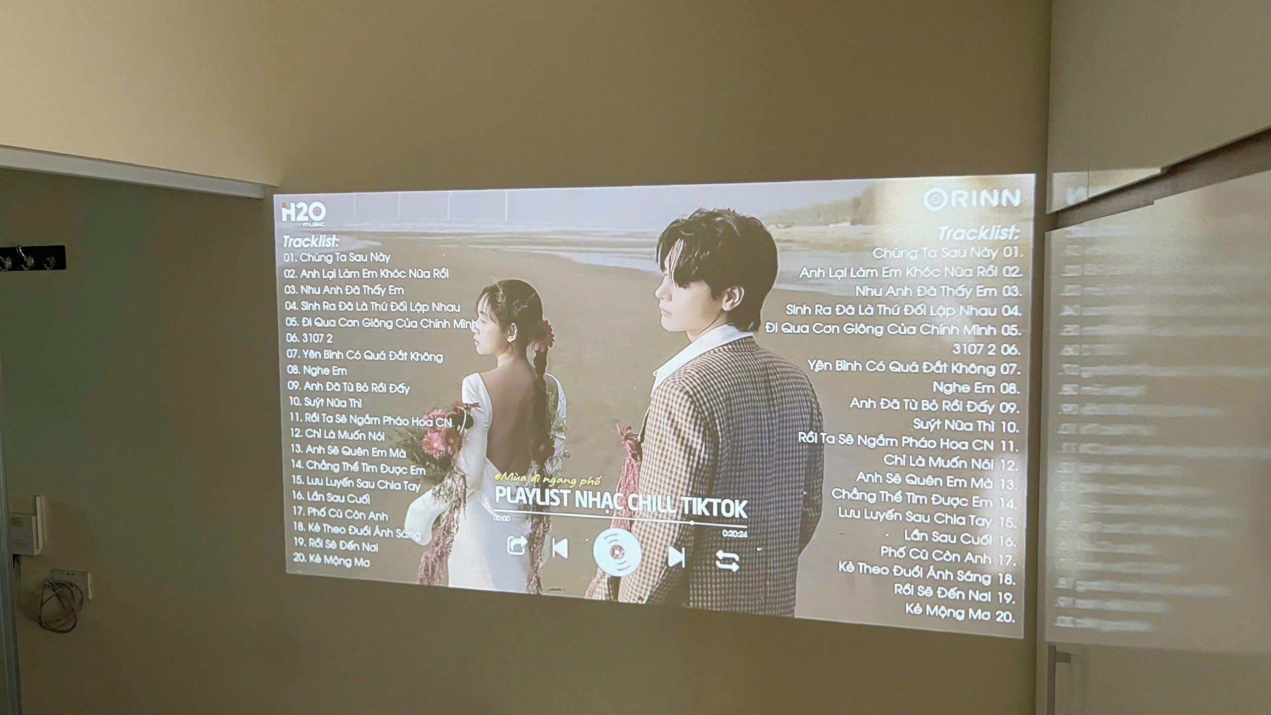 A projection of a playlist with song titles in Vietnamese.