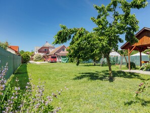 A residential area with houses, a green lawn, and a tree.