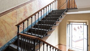 A staircase with black balusters and wooden handrails, leading to an upper floor. - Bright and spacious one-bedroom apartment of almost 100 square meters located in Via Carlo d'Adda 5, in the heart of Milan, in an IN area full of life and with numerous connections via local transportation (P.ta Genova FS station and metro stop a few min (Milano)