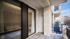 A modern apartment with a sliding glass door leading to a balcony, a visible bathroom, and a city view. - Two-room apartment Cecchi 18 2p - Mirable PM (Milano)