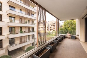 A modern apartment with multiple balconies, large windows, and potted plants.