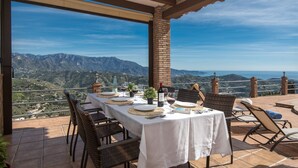 An outdoor dining area with a table set for two, overlooking a mountainous landscape. - Casa Ascen by At Home Costa del Sol (Torrox)