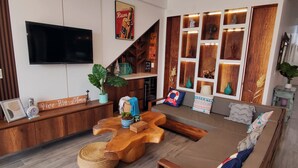 A modern living room with a wooden coffee table, a sofa, and a TV mounted on the wall. - Between Mala and Asia Boulevard, Bujama Beach house in Moravia II! (Bujama, Asia)