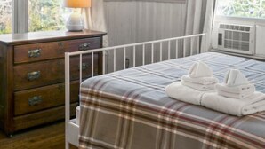 Un dormitorio con cama, cómoda, lámpara y decoración de peces en la pared.