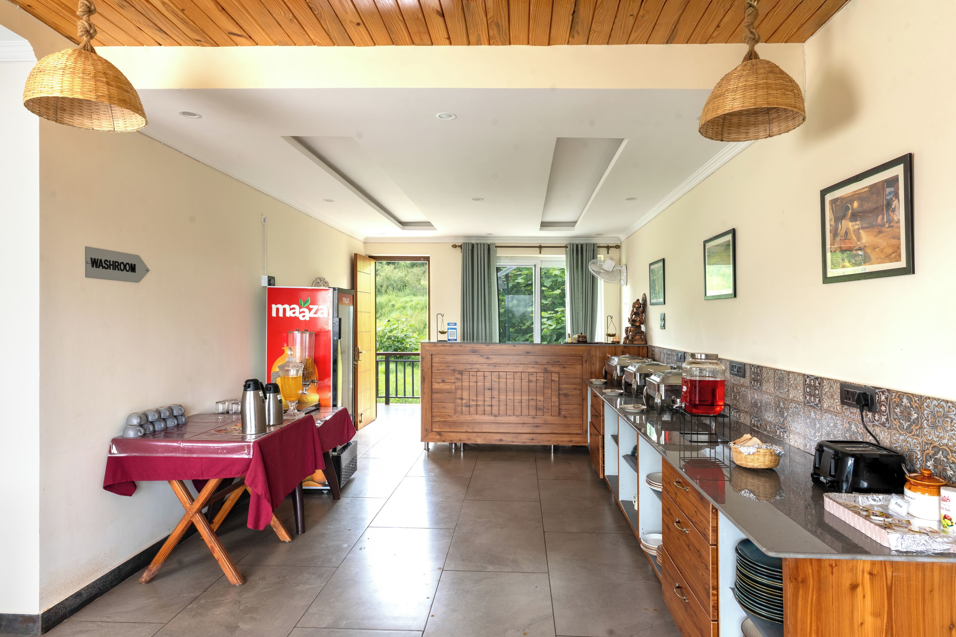 A kitchen with a dining area, a sign for the washroom, and a buffet counter.