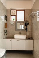 A modern bathroom with a white sink, a mirror, a telephone, and a towel rack.