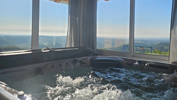 Una vasca idromassaggio con vista sulla città attraverso ampie finestre.