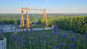 Altalena in legno in un giardino con vista su un paesaggio lontano.