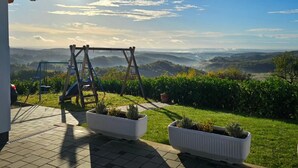 Un patio con altalena che si affaccia su un paesaggio suggestivo.