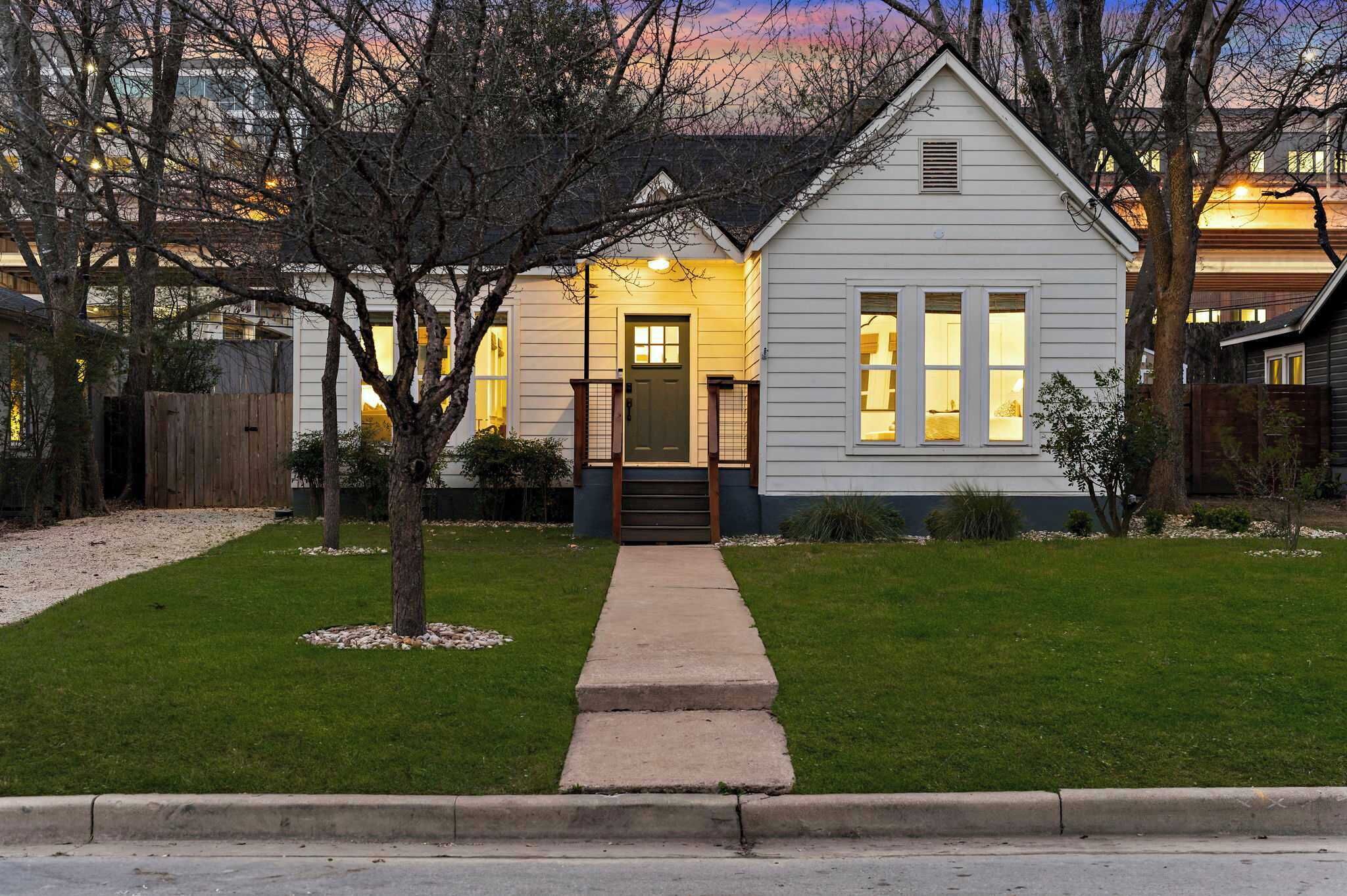 A single-story house with a front door, a small porch, and a well-maintained lawn.