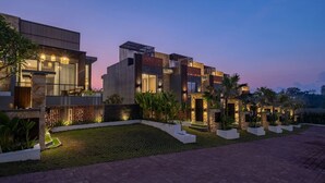 Ein modernes, mehrgeschossiges Haus mit gepflegtem Garten und gepflasterter Auffahrt.