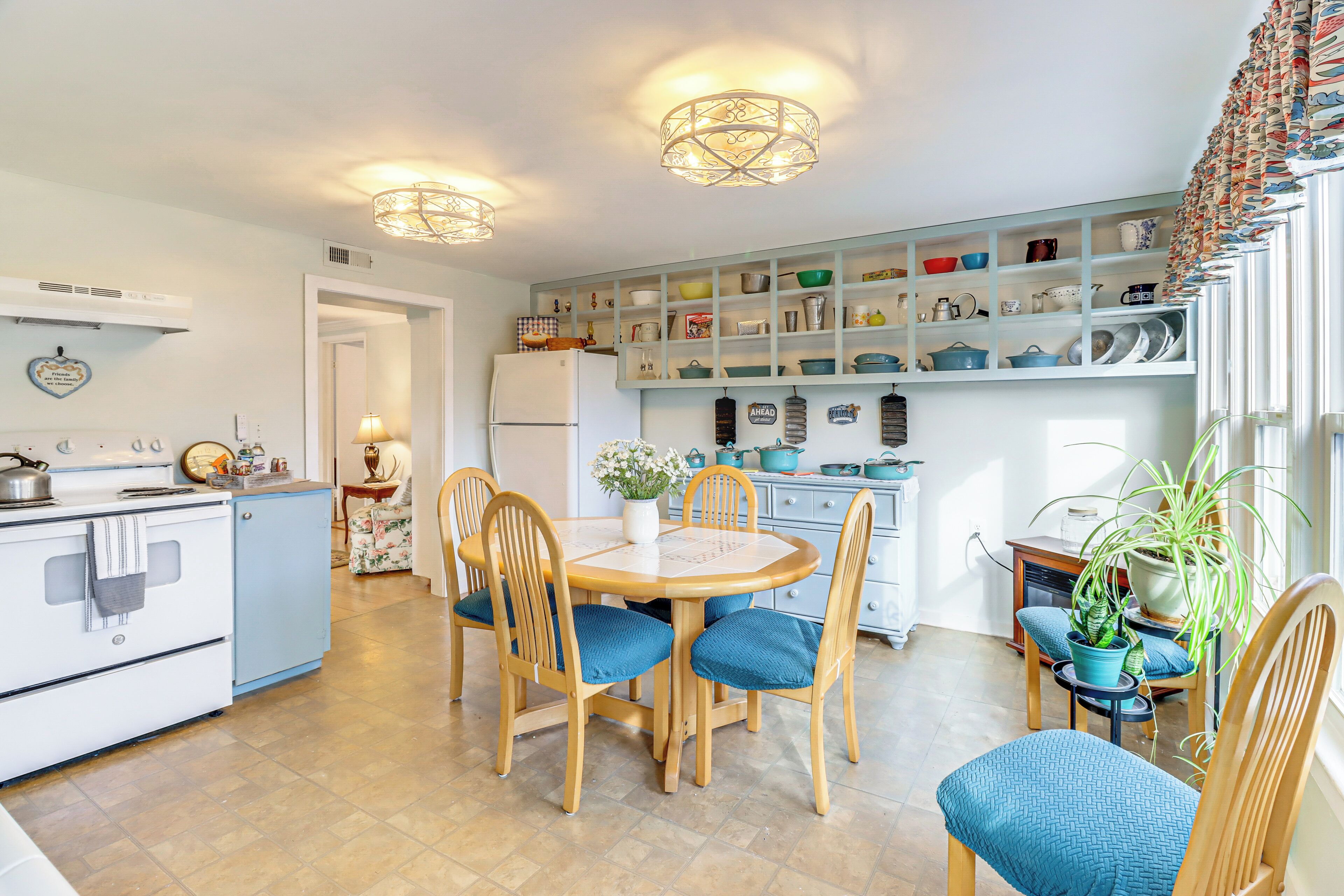 A kitchen with a dining table, chairs, and a refrigerator.