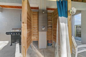 A sauna room with wooden walls, a sauna, a bench, and a grill.