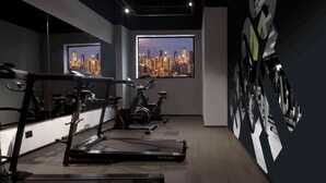 A gym with treadmills, stationary bikes, and a cityscape view through large windows. - Merica Hotel -Chengdu Chunxi Road (Chengdu)
