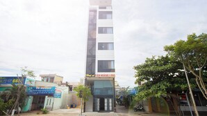 A modern building with a sign reading "TAN HOANG LONG" at the entrance.