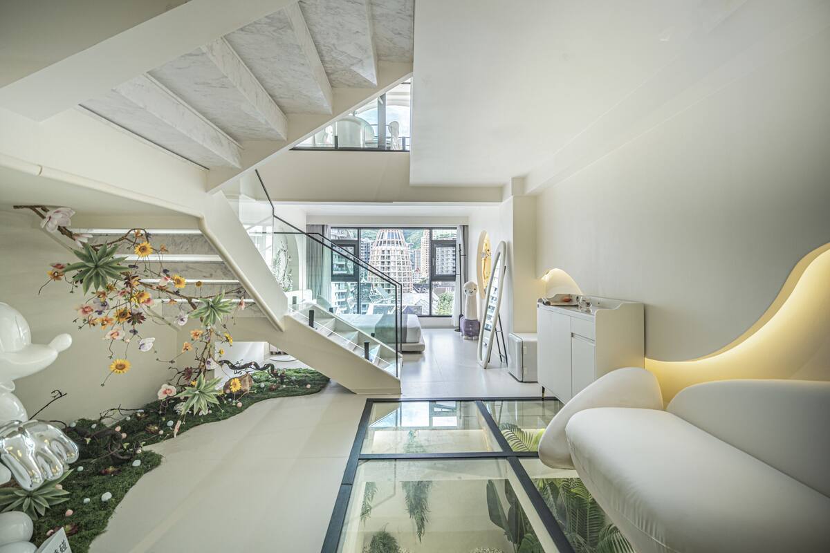 Un intérieur moderne avec un escalier, un canapé et une table en verre.