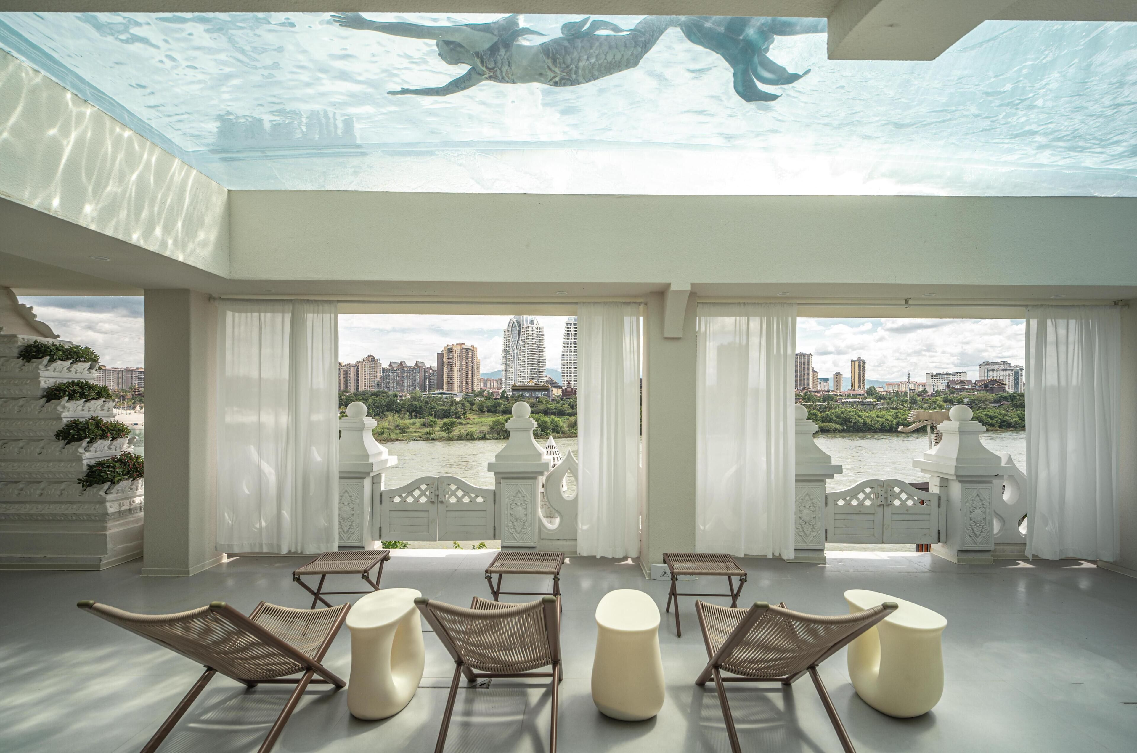 A spacious room with a city view, featuring a pool table, comfortable seating, and a decorative ceiling.
