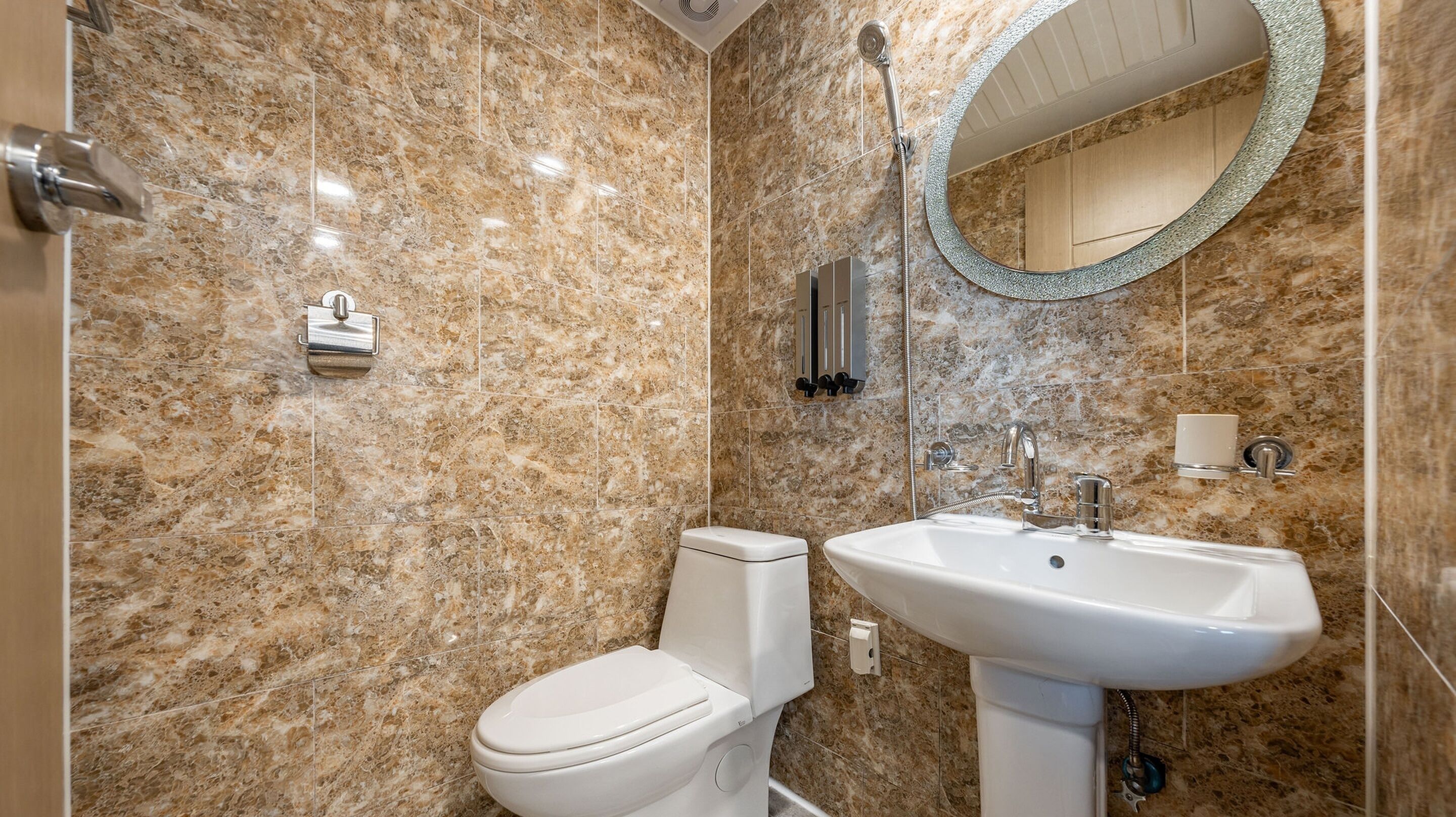 Une salle de bain avec des toilettes, un lavabo et une douche.