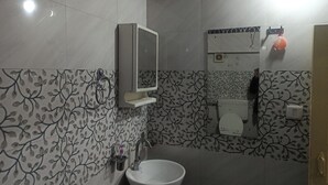 Een badkamer met toilet, wastafel en spiegel.
