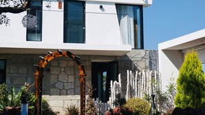 Un edificio moderno con tejado de baldosas tradicionales, fachada de piedra y un arco de madera.
