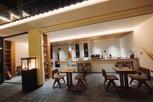 A cozy restaurant with wooden furniture and a central fire feature.