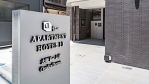 Segnale per 'APARTMENT HOTEL II OsakaDome' con un design moderno.