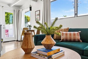 Una sala moderna con una mesa de centro de madera, un florero de madera y libros.
