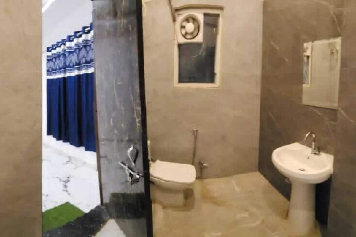 A bathroom with a toilet, sink, and a mirror.
