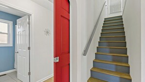 A staircase with wooden steps and a red door. - Sultan MAIN · Metro | Location | Convenience | Budget | 3 queen (Capitol Heights)