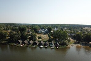 A lakeside property with multiple cabins, a central building, and a surrounding forest.