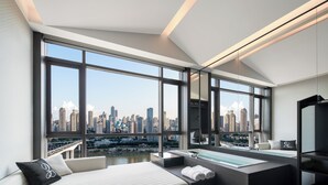A modern hotel room with a large city view, a bed, a sitting area, and a bathtub. - INDITION Chongqing Jiangbeizui Financial (Chongqing)