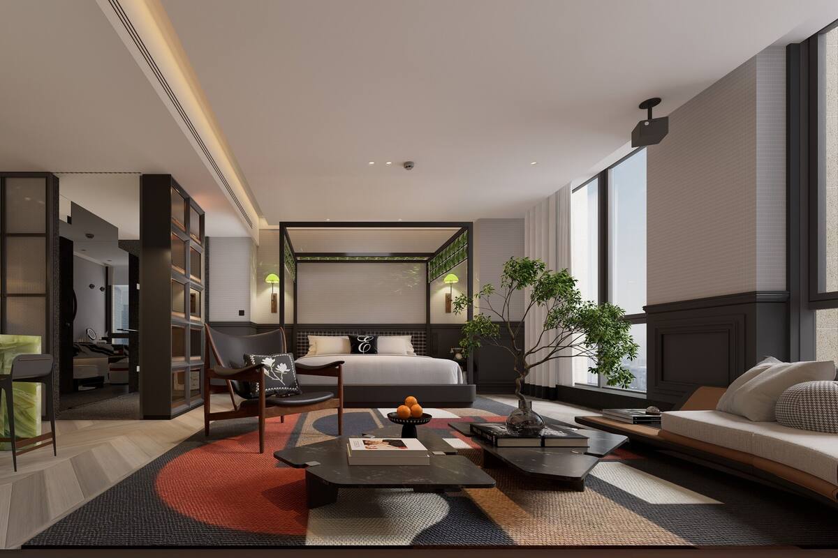 Een moderne hotelkamer met een bed, zithoek en uitzicht op de stad.
