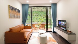 Una sala de estar moderna con un sofá, una mesa de centro y un televisor sobre un mueble.