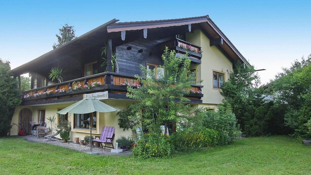 A two-story building with a balcony, a covered patio area, and a garden. - Apartment in Schonau am Konigsee in Top Location (Schoenau am Koenigssee)