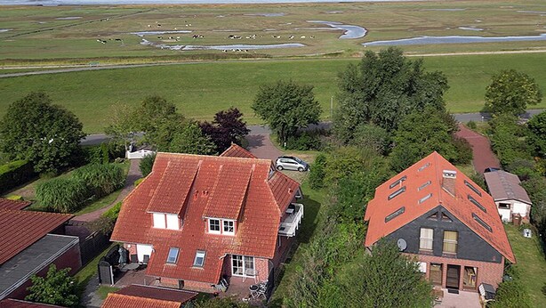 A residential area with houses, a road, and a coastal landscape. - Fantastic vacation apartment directly on the dike (Wurster Nordseeküste)