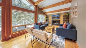 Un salón espacioso con ventanas amplias, chimenea y una zona de estar acogedora.
