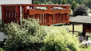 A wooden balcony with a view of a forested mountain range. - Holiday Apartment 'Type B, 70sqm' with Mountain View, Private Terrace and Wi-Fi (Schluchsee)