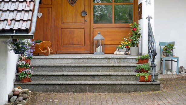A wooden door with a heart decoration, a set of stone steps leading to a door, and potted plants on either side. - Holiday Apartment 'Type B, 70sqm' with Mountain View, Private Terrace and Wi-Fi (Schluchsee)
