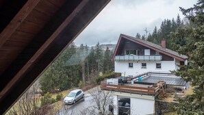 A modern two-story house with a sloped roof, a covered patio, and a car parked in the driveway.