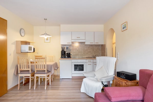 A compact living space with a kitchenette, dining area, and seating.