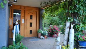 A wooden door with a small window, a blue and white striped object, and potted plants. - Apartment 'Monika' with Mountain View, Balcony and Wi-Fi (Schonach im Schwarzwald)