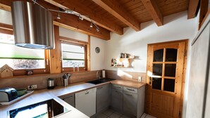 A kitchen with wooden beams, a sink, a dishwasher, and a window. - Apartment 'Monika' with Mountain View, Balcony and Wi-Fi (Schonach im Schwarzwald)