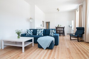 Una sala de estar moderna con un sofá, una mesa de centro, una silla y un comedor.
