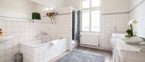 Un baño moderno con bañera, lavamanos, inodoro y ventana.